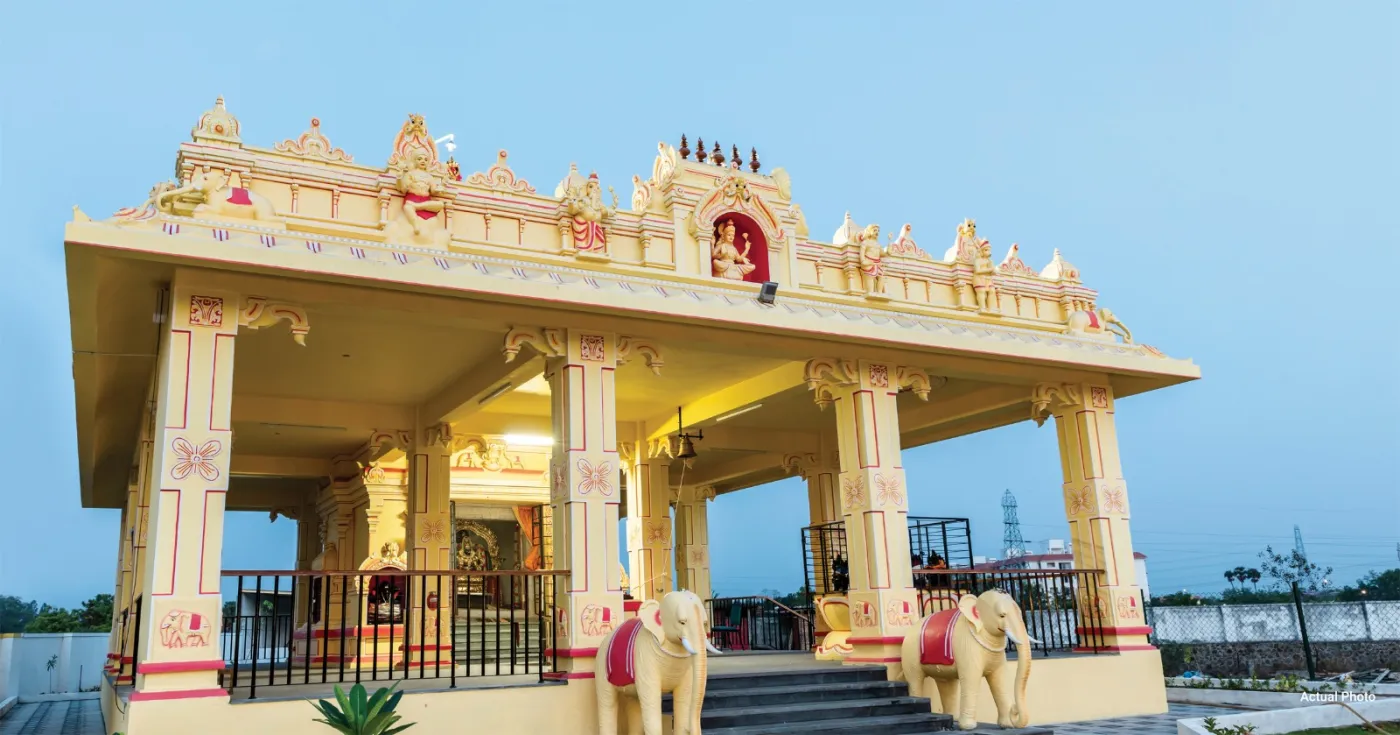 The Sri Swarna Mahalakshmi temple inside Harmonia, at dusk. It is a walk from the villas, not a journey.