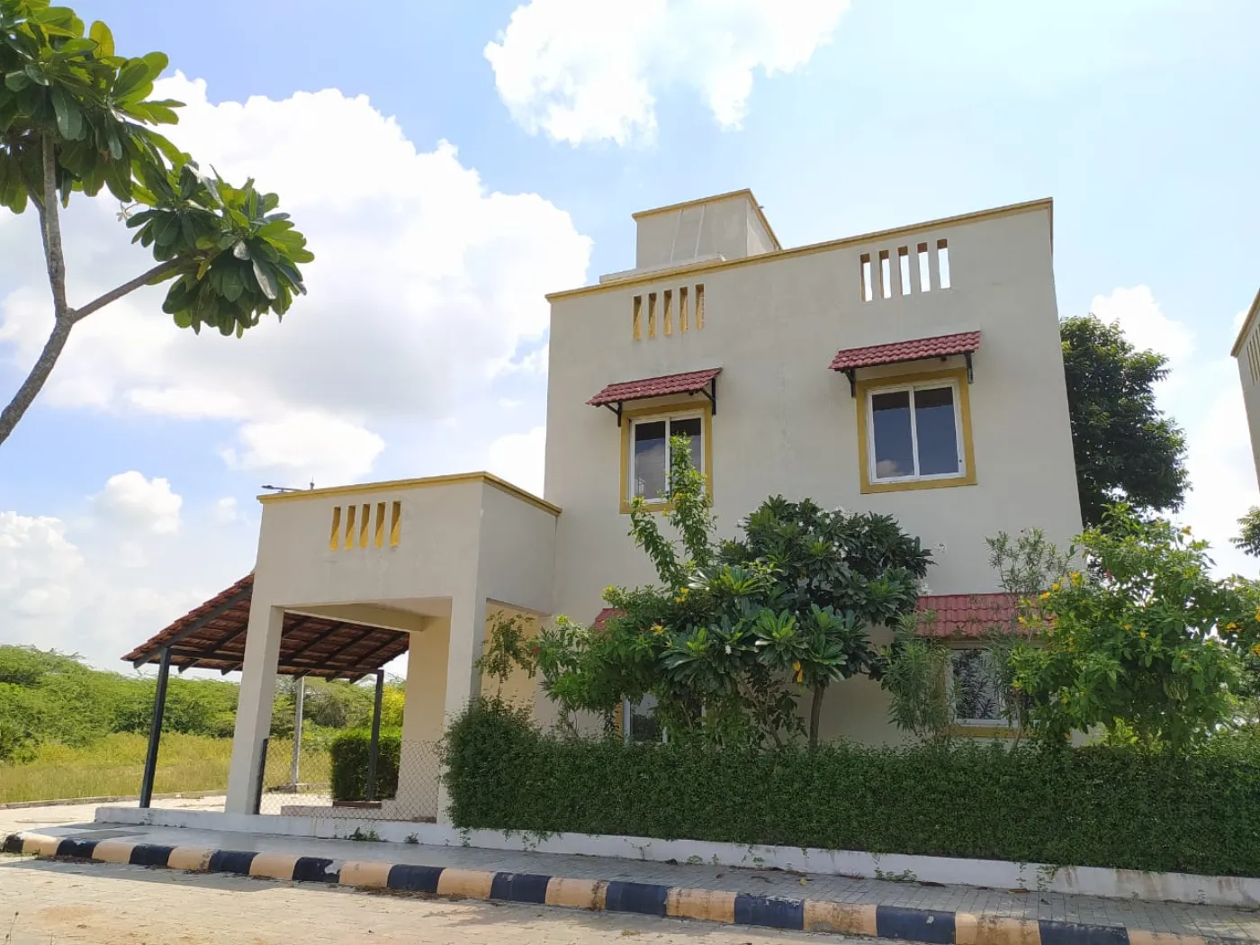 Photograph. A Harmonia duplex villa: two levels, its own car porch and its own garden, with the hedge grown in.